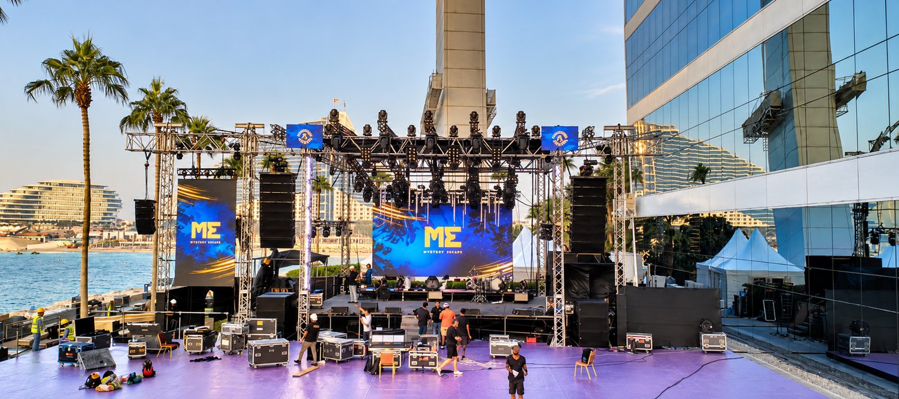 Mystery Escape outdoor beach stage with lighting truss and LED screens in Dubai, built by Morph